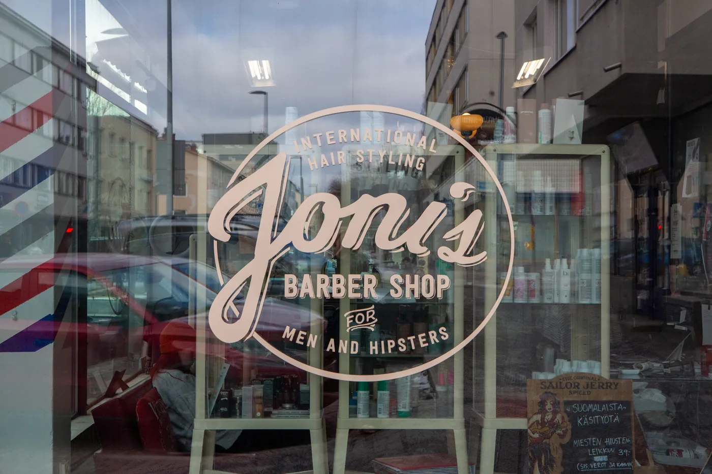 Joni&rsquo;s Barber Shopin logo liikkeen ikkunassa Isokadulla